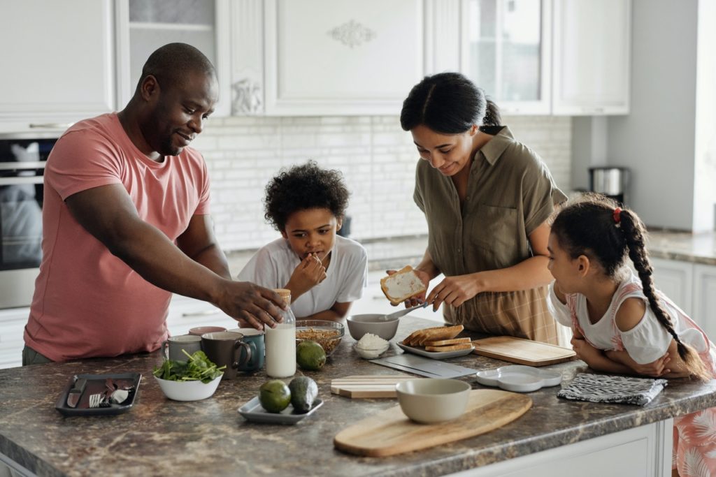 Family at kitchen island preparing meal